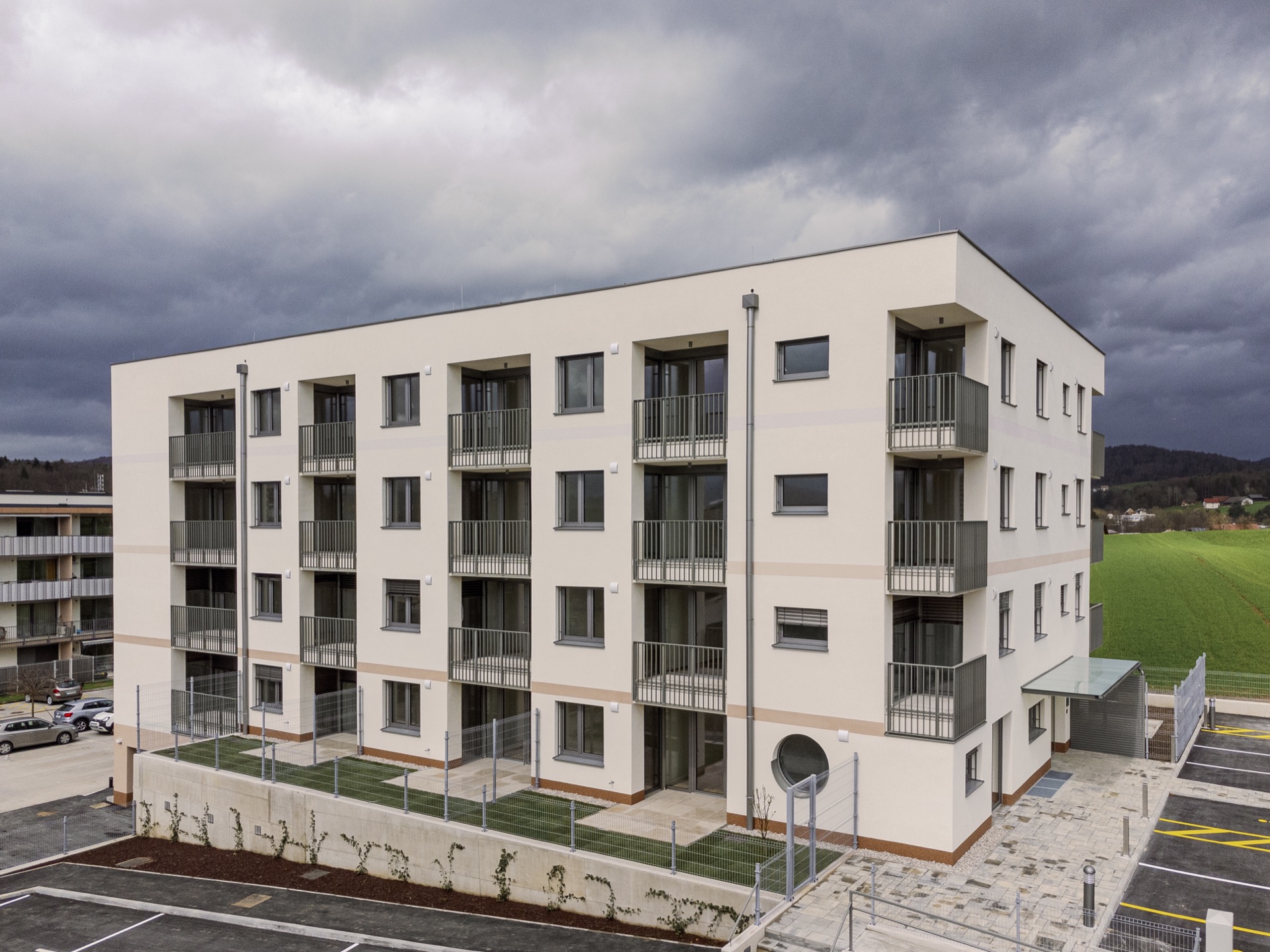 White residential apartment building under a dramatic sky